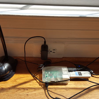 A Raspberry Pi connected to a microphone in front of a window